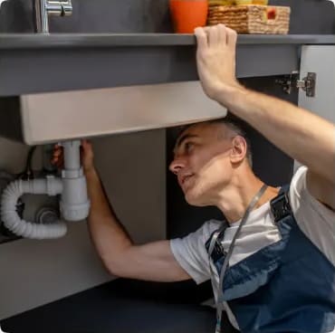 Plumber clearing a sink drain